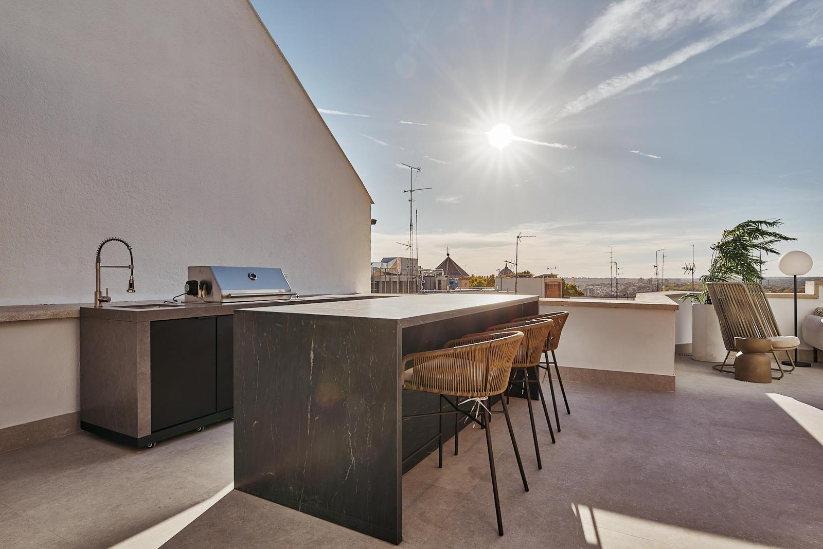 Cocina exterior con barra · Ático dúplex con piscina en Leganitos 18, Madrid